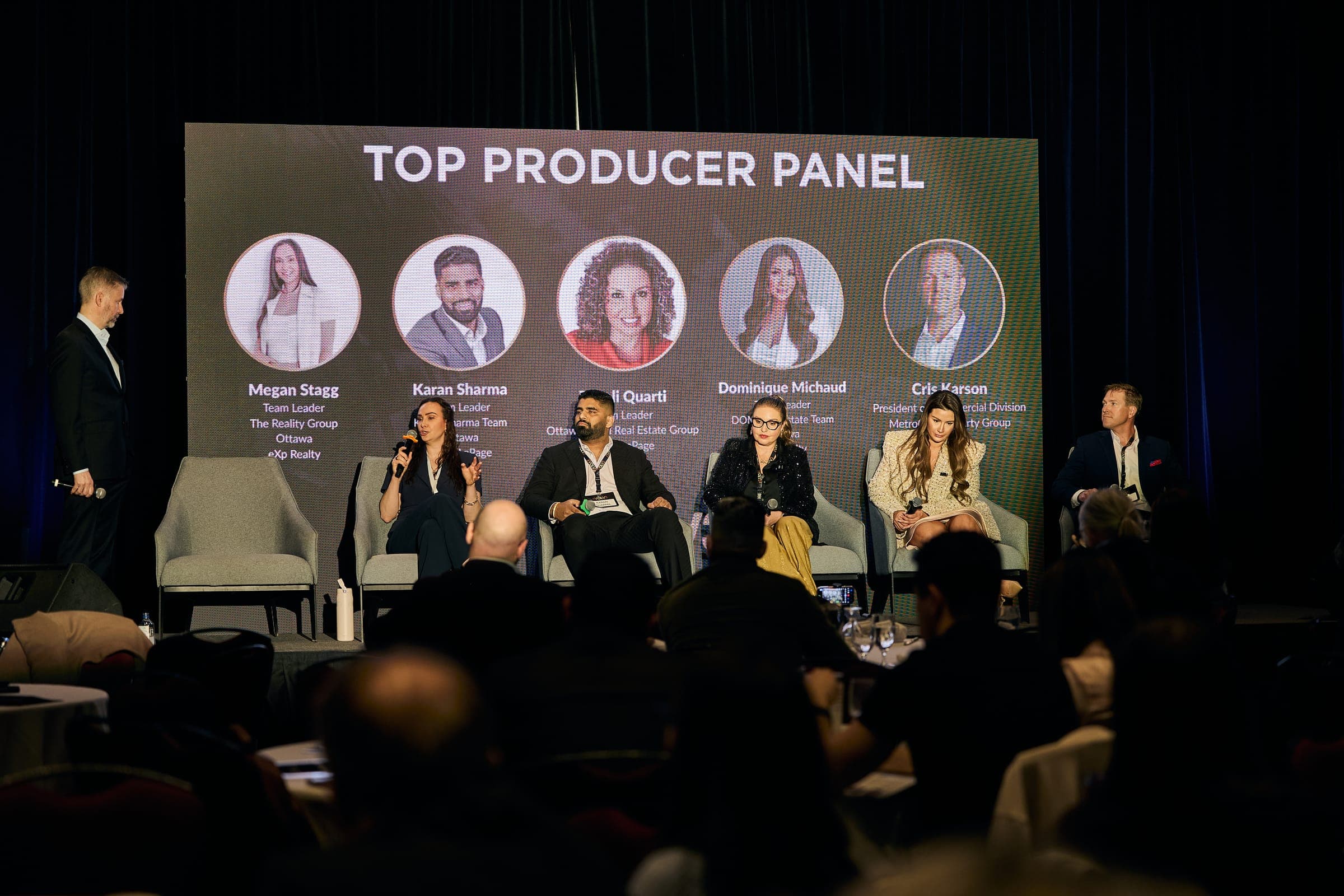 A "Top Producer Panel" on stage at Evolv3 with five panelists seated, Megan Stagg named on the screen